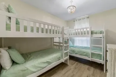 two white bunk beds in a room at Emerald Coast Villa in Panama City Beach