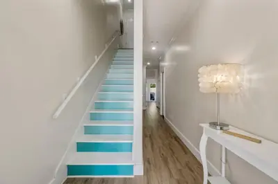 a staircase with blue steps in a white hallway at Emerald Coast Villa in Panama City Beach