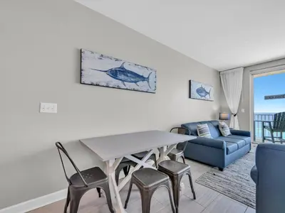 a living room with a table and chairs and a couch at Shores of Panama 1002 in Panama City Beach