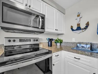 a kitchen with a stove and a microwave at Shores of Panama 1002 in Panama City Beach