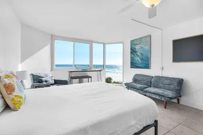a bedroom with a large bed and a view of the ocean at Top of the Gulf 421 - Luxury Beach View Condo in Panama City Beach