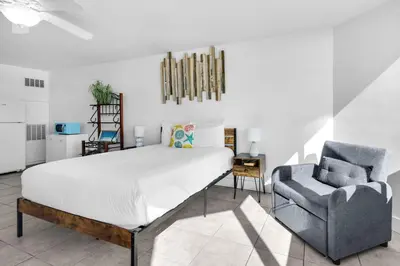 a bedroom with a bed and a chair at Top of the Gulf 421 - Luxury Beach View Condo in Panama City Beach