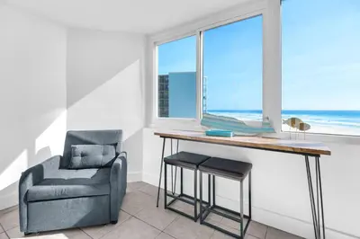 a desk and a chair in a room with a window at Top of the Gulf 421 - Luxury Beach View Condo in Panama City Beach