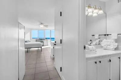 a white bathroom with a view of the ocean at Top of the Gulf 421 - Luxury Beach View Condo in Panama City Beach