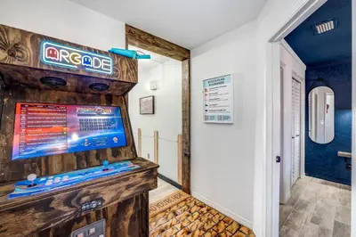 a room with a video game on the wall at The Beachy Boater at St Thomas Square #305 by Nautical Properties in Panama City Beach