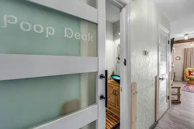 a hallway with a door leading into a room at The Beachy Boater at St Thomas Square #305 by Nautical Properties in Panama City Beach