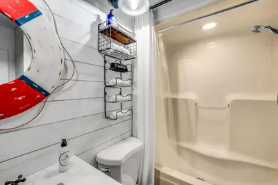 a bathroom with a toilet and a sink and a shower at The Beachy Boater at St Thomas Square #305 by Nautical Properties in Panama City Beach