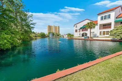 a river in a city with buildings next to it at The Beachy Boater at St Thomas Square #305 by Nautical Properties in Panama City Beach