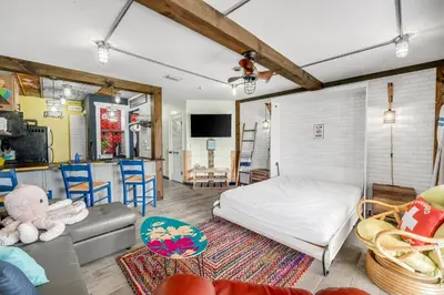 a bedroom with a bed and a living room at The Beachy Boater at St Thomas Square #305 by Nautical Properties in Panama City Beach