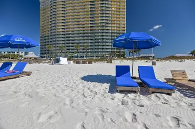 two blue chairs and umbrellas on a beach at Boardwalk Beach Resort #1400 by Book That Condo in Panama City Beach