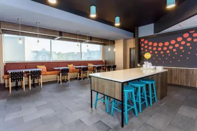 a restaurant with tables and chairs and a large window at Tru By Hilton Panama City Beach in Panama City Beach
