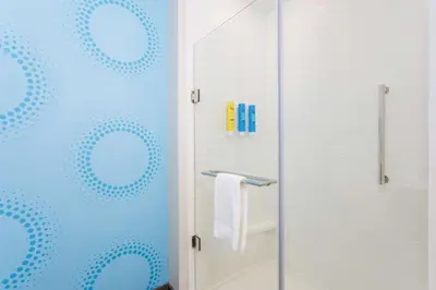a bathroom with a shower with a glass door at Tru By Hilton Panama City Beach in Panama City Beach