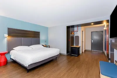 a bedroom with a large white bed and wooden floors at Tru By Hilton Panama City Beach in Panama City Beach
