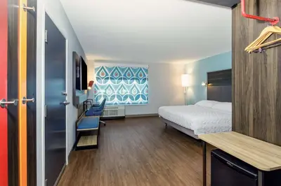 a small room with a bed and a desk at Tru By Hilton Panama City Beach in Panama City Beach
