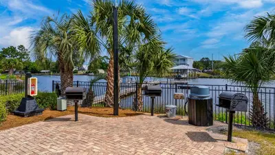 a group of trash cans and palm trees next to a fence at St Thomas Square 1208A in Panama City Beach