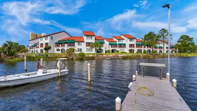 a boat docked at a dock in front of a building at St Thomas Square 1208A in Panama City Beach