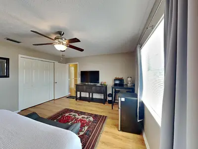 a living room with a bed and a ceiling fan at Gulf Six in Panama City Beach