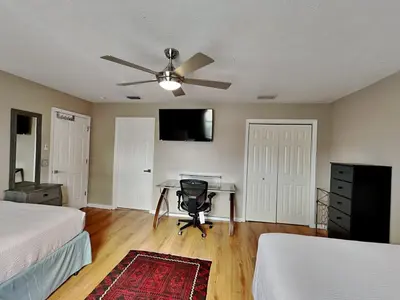a bedroom with two beds and a desk with a ceiling fan at Gulf Six in Panama City Beach