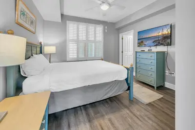 a bedroom with a bed and a desk at Aqua Resort 903 in Panama City Beach