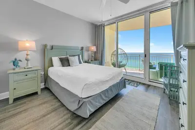a bedroom with a bed and a balcony at Aqua Resort 903 in Panama City Beach