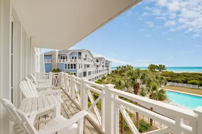 a balcony with white chairs and a view of the ocean at Gulf Front - Large Pool - Bikes - Gated Community in Inlet Beach