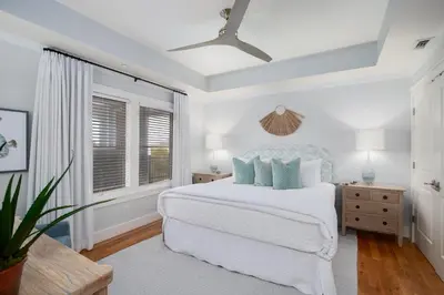 a white bedroom with a bed and a ceiling fan at Gulf Front - Large Pool - Bikes - Gated Community in Inlet Beach
