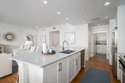 a white kitchen with a sink and a counter at Gulf Front - Large Pool - Bikes - Gated Community in Inlet Beach