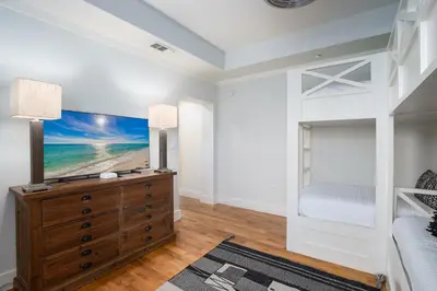 a bedroom with a bed and a tv on a dresser at Gulf Front - Large Pool - Bikes - Gated Community in Inlet Beach
