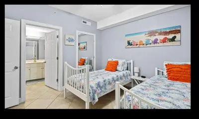 a bedroom with two beds and a bathroom at Beautiful Beachfront Views - The Retreat at Emerald Isle in Panama City Beach