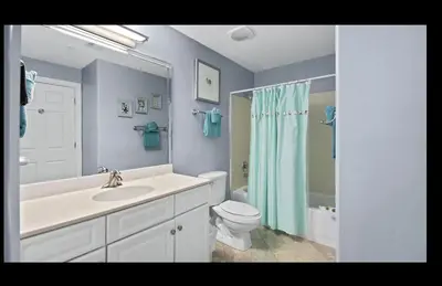 a bathroom with a sink and a toilet and a mirror at Beautiful Beachfront Views - The Retreat at Emerald Isle in Panama City Beach