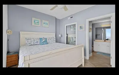 a bedroom with a white bed with blue pillows at Beautiful Beachfront Views - The Retreat at Emerald Isle in Panama City Beach