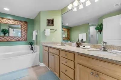 a bathroom with two sinks and a bath tub and a tubermott at Beachfront Bliss Luxe 3BR Condo at Marisol Complex in Panama City Beach