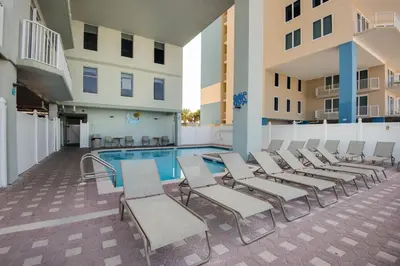 a group of chairs and a pool in a building at Beachfront Bliss Luxe 3BR Condo at Marisol Complex in Panama City Beach