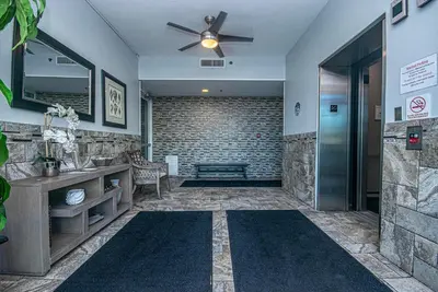 a bathroom with a ceiling fan and a stone wall at Beachfront Bliss Luxe 3BR Condo at Marisol Complex in Panama City Beach