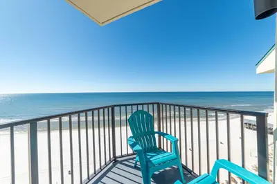 a blue chair sitting on a balcony overlooking the beach at Sunbird 1204W 'Humphries Hideaway' in Panama City Beach