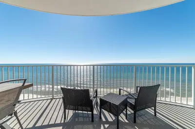 a balcony with chairs and tables and the ocean at Twin Palms 1903 'No Bad Days' in Panama City Beach