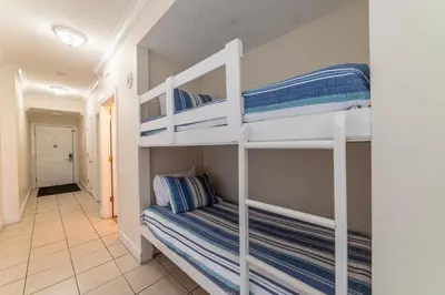 a bedroom with two bunk beds and a hallway at Twin Palms 1903 'No Bad Days' in Panama City Beach