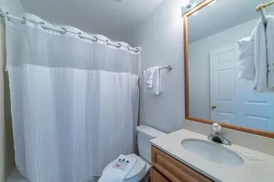 a bathroom with a sink and a toilet and a mirror at Twin Palms 1903 'No Bad Days' in Panama City Beach