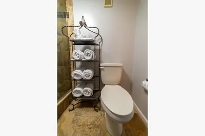 a bathroom with a toilet and towels on a shelf at Edgewater 3-1113 'Ocean's 1113' in Panama City Beach