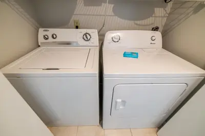 a white refrigerator and a washer and dryer in a room at Edgewater 3-1113 'Ocean's 1113' in Panama City Beach