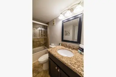a bathroom with a sink and a toilet and a mirror at Edgewater 3-1113 'Ocean's 1113' in Panama City Beach