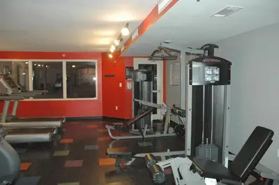 a gym with cardio equipment in a room with red walls at Shores of Panama 1520 'Thirsty Turtle' in Panama City Beach