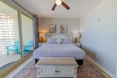a bedroom with a bed and a balcony at Shores of Panama 1520 'Thirsty Turtle' in Panama City Beach
