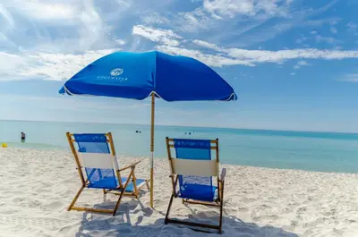 two chairs under an umbrella on a beach at Edgewater 1-0502 'Island Paradise' in Panama City Beach