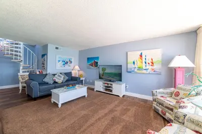 a living room with a couch and a tv at Edgewater 2-1202 'Shore Fun Penthouse' in Panama City Beach