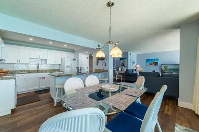 a kitchen and living room with a table and chairs at Edgewater 2-1202 'Shore Fun Penthouse' in Panama City Beach