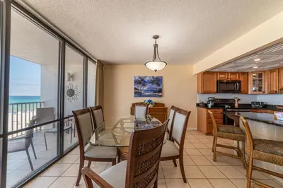 a kitchen and dining room with a glass table and chairs at Edgewater L301 'The Nauti Starfish' in Panama City Beach