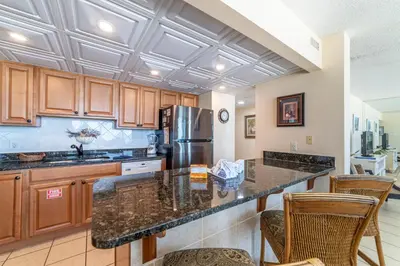 a kitchen with a counter top and a refrigerator at Edgewater L301 'The Nauti Starfish' in Panama City Beach