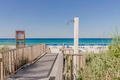 a wooden walkway to the beach with the ocean at Boardwalk 0605 'Good Times & Tan Lines' in Panama City Beach