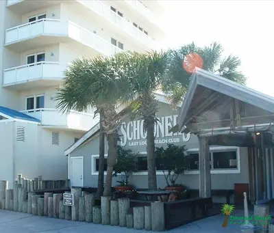 a restaurant with palm trees in front of a building at Boardwalk 0605 'Good Times & Tan Lines' in Panama City Beach